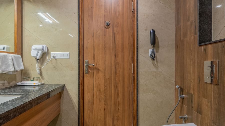 Bathroom with modern fixtures and wooden finishes at Hotel Highway King, Bagru.