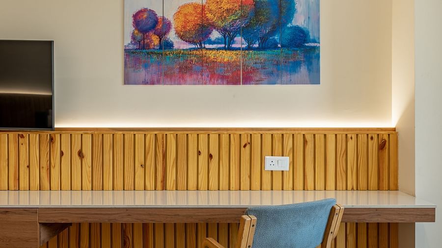 A wall mounted, wooden, work desk and entertainment unit in the executive king room in Hotel Highway King, Bagru.
