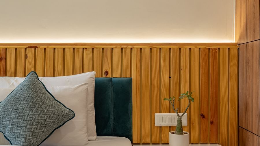 Close-up of cosy bed and nightstand with minimalist design in an executive king room at Hotel Highway King, Bagru.