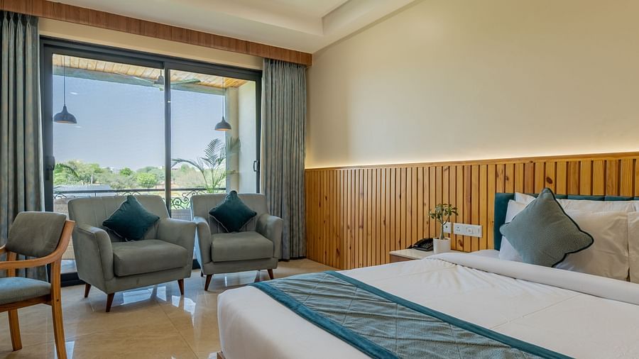 King size bed near balcony with garden view at Hotel Highway King, Bagru.
