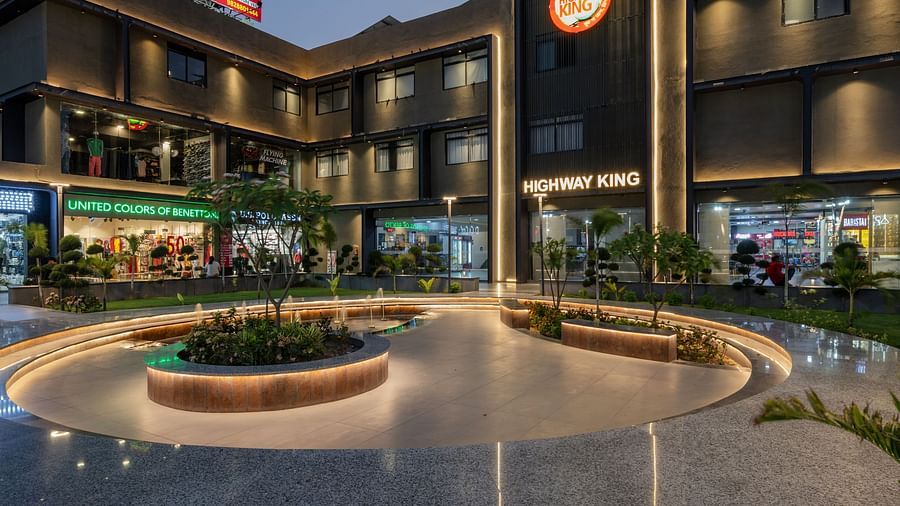 External view of Hotel Highway King, Behror, featuring a well-lit facade, an illuminated logo and a well-manicured lawn.