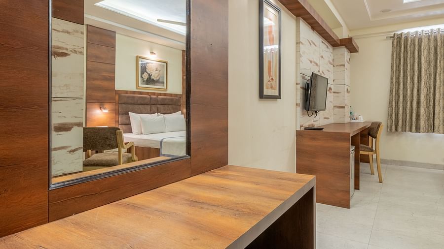 A wooden dressing table with mirror and storage drawers at Hotel Highway King, Jaipur.