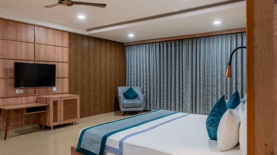 A spacious guest room at Hotel Highway King Shahpura with a bed, TV, and modern decor.