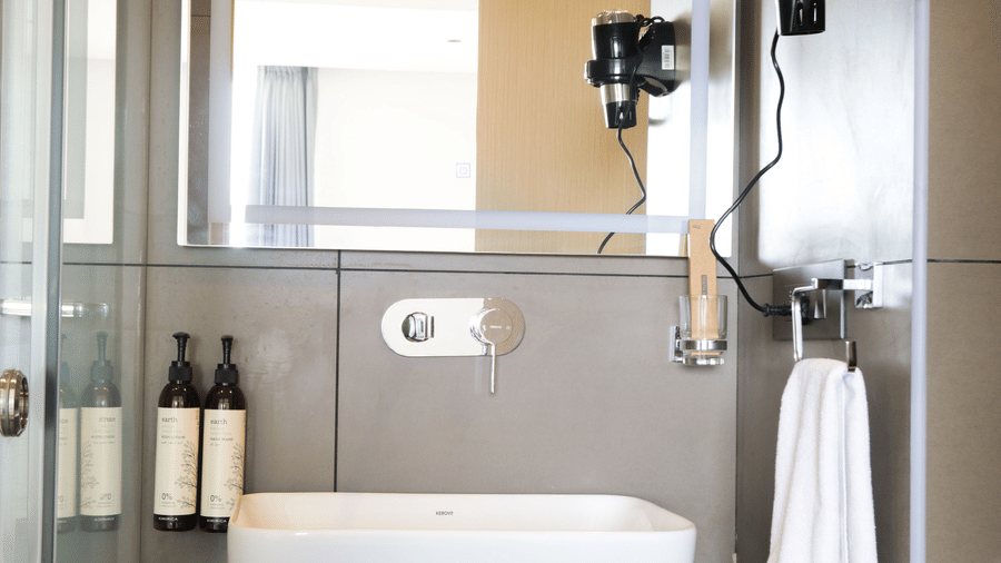 Modern bathroom with bathtub and shower fittings in Luxury Suite at Hotel Kyzen HiTech City – Your Zenly Stay.