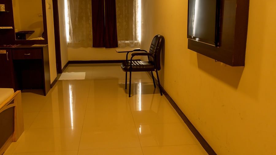 a room with a television mounted on the wall and a chair on the far end of the room