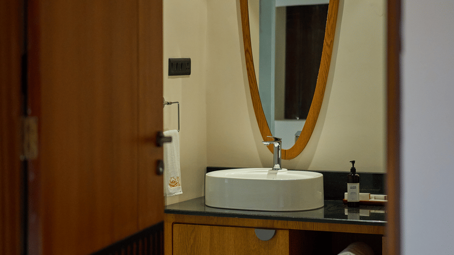A view through a doorway featuring a bathroom with a vanity and a mirror at Hotel Sonar Bangla, Ajodhya Hills.