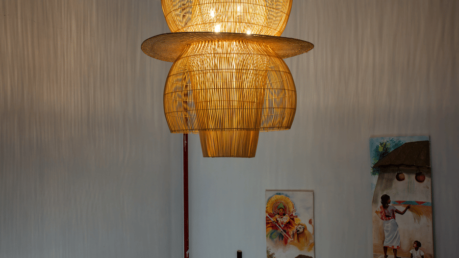 A stairwell featuring a layered wooden hanging light fitting at Hotel Sonar Bangla, Ajodhya Hills.