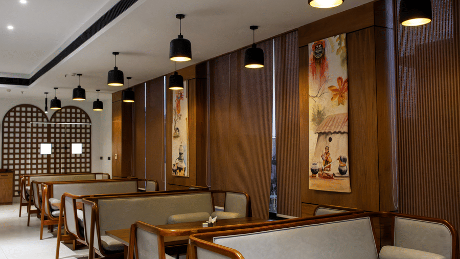 A dining space featuring wooden tables, cushioned benches, and wood-panelled walls at Hotel Sonar Bangla, Ajodhya Hills.