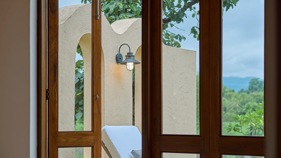 An indoor view featuring an open glass door looking out onto a patio at Hotel Sonar Bangla, Ajodhya Hills.