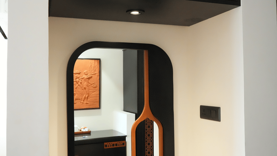 An interior view featuring a built-in dark wooden unit with an oval mirror and upper cabinets at Hotel Sonar Bangla, Ajodhya Hills.