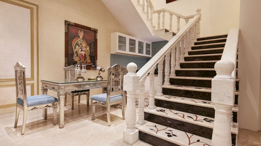 An elegant staircase and hallway with contemporary paintings and sleek white marble flooring - Kaldan Samudhra