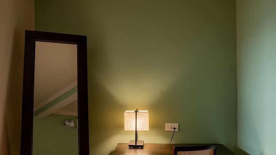 Compact writing desk and full-length mirror in a softly lit corner of a stylish room at Kssemya.