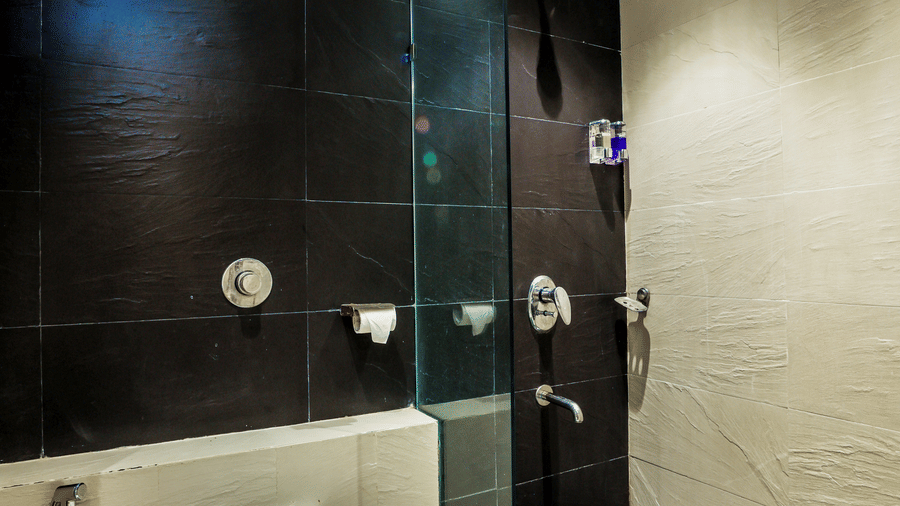 Bathroom with a glass shower area and neatly arranged essentials at Kumar Resort by Turtle.