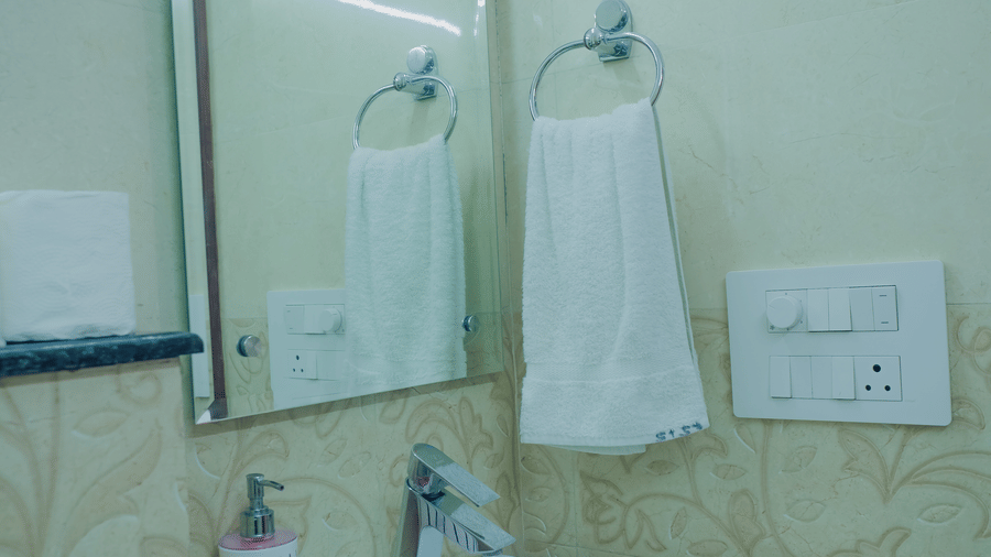 Bathroom of Lime Tree Hotels & Service Apartment Private Limited featuring a white basin and a mirror.
