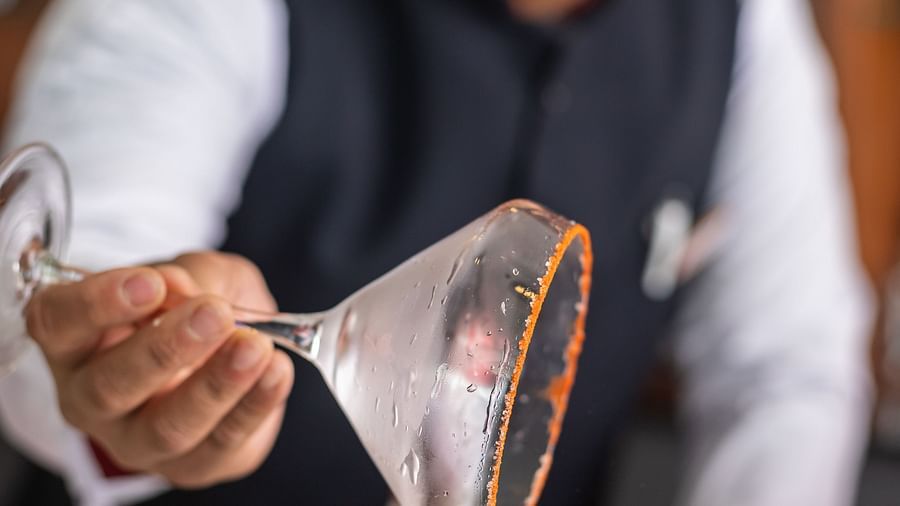 A bartender rimming a martini glass with a powder at Mandala Norling Lords Prime in Kathmandu.