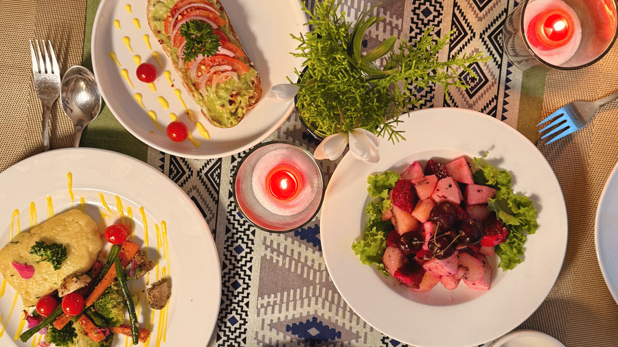 A top view of a table filled with assorted plated dishes including salads and tacos - Megha Resort & Villas, Dehradun