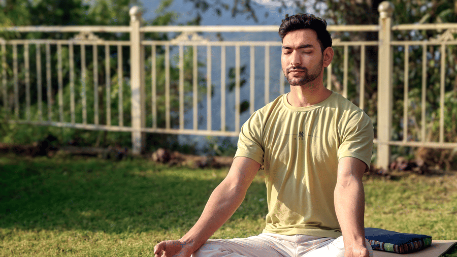 a man sitting on a yoga mat doing a meditation pose