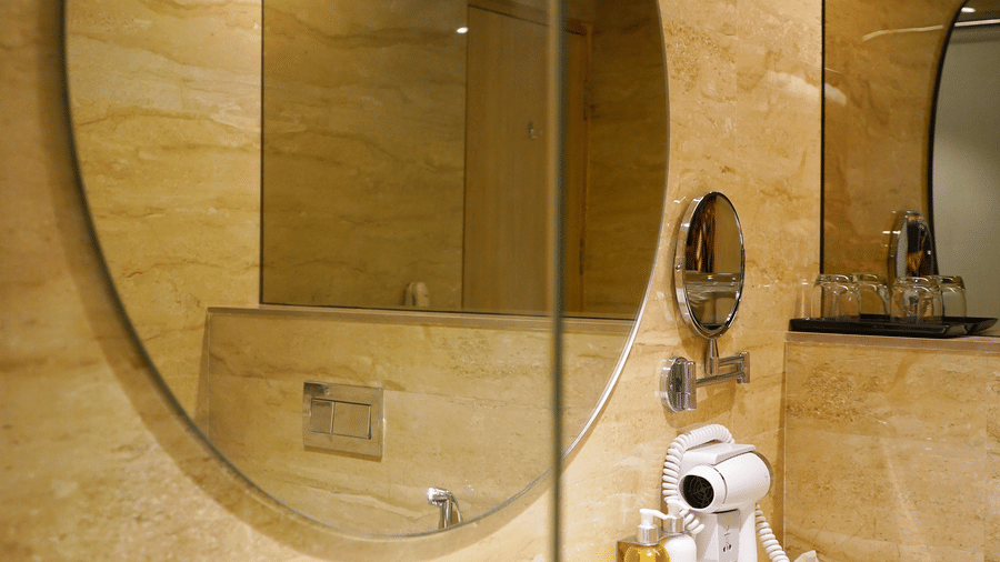 Modern bathroom at Nemesia featuring a large mirror and stylish fixtures.