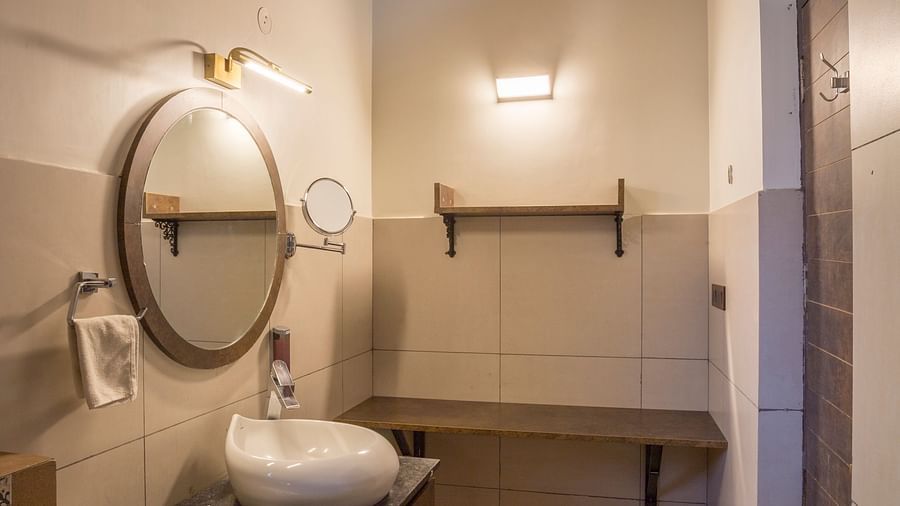 Compact bathroom with modern vanity and mirror at Nirantara Resort & Spa