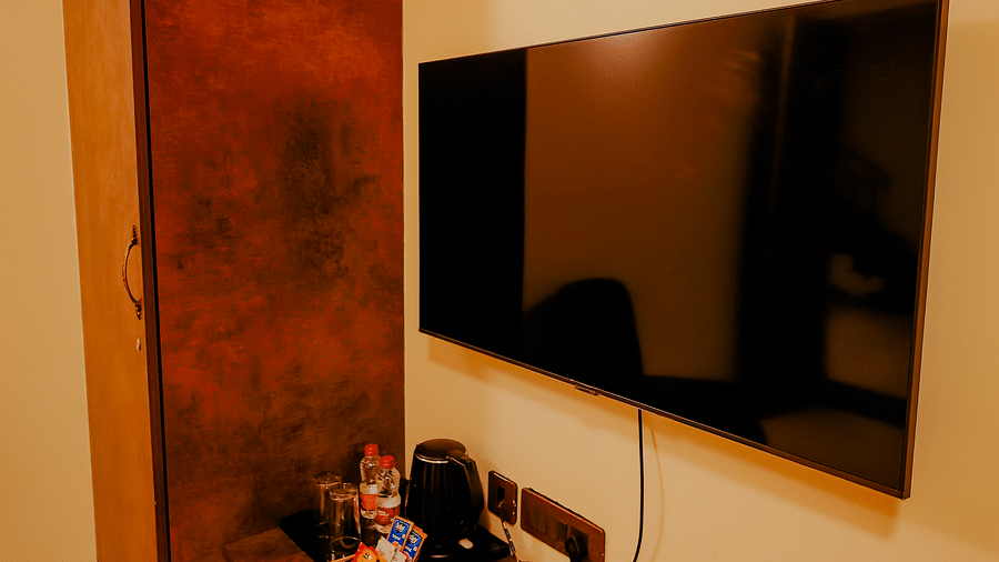 A television mounted on the wall in a room at Nirantara Resort & Spa.