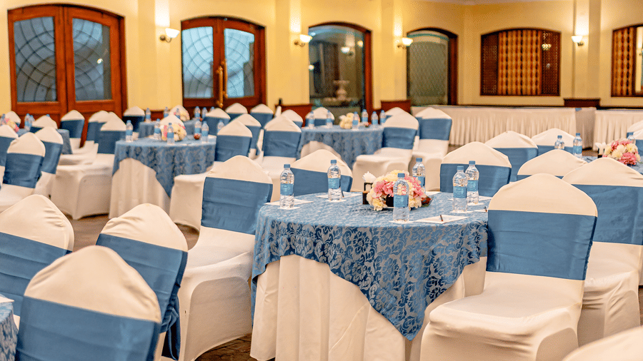Close up of the tables of the Emperor Hall decorated with flowers along with the stationery items kept on the table at Noor-Us-Sabah Palace, Bhopal.