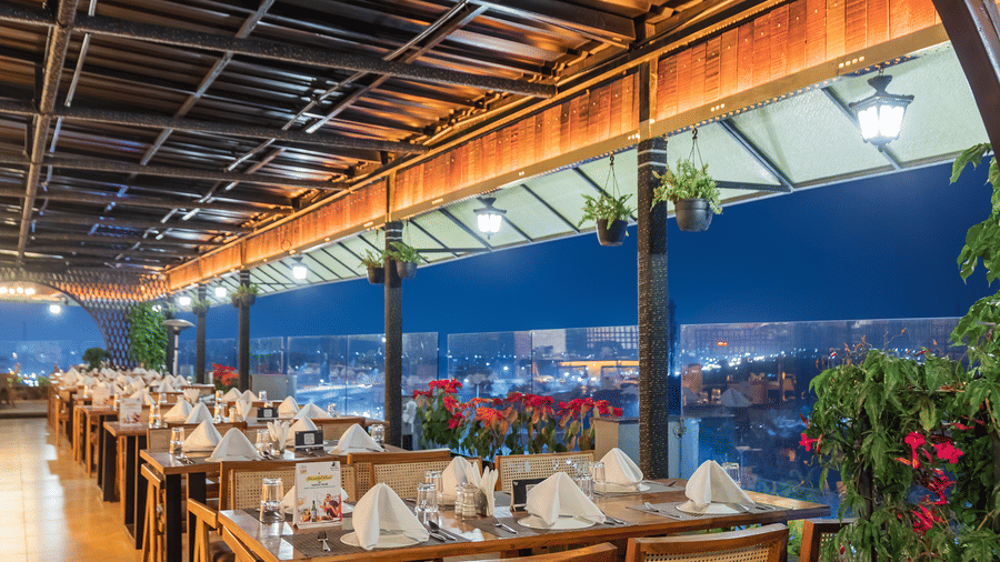 The Hills View restaurant at The Papaya Tree Hotels offering cosy seating with a warm ambience and greenery, perfect for enjoying meals while taking in the outdoor surroundings.