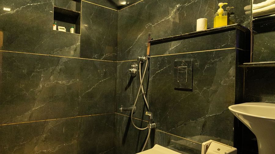 Image of a washroom with a toilet and shower area at Parampara Resort & Spa, Kushalnagar.