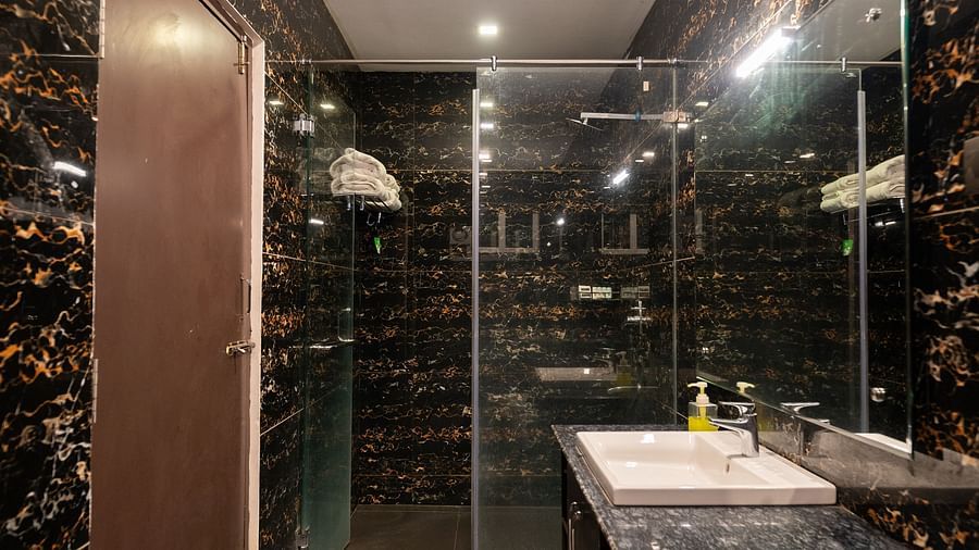 Image of a washroom with a separate shower area and a sink at Parampara Resort & Spa, Kushalnagar.