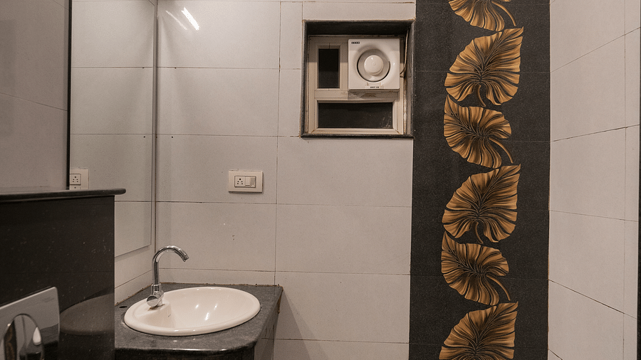 A washroom with a sink and a toilet at Parampara Resort & Spa, Kushalnagar.