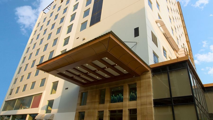 An exterior shot of our hotel taken from a lower angle with a lawn area in the foreground - Ramada by Wyndham, Ghaziabad, Vasundhara
