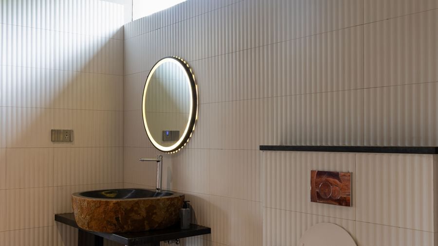 A modern bathroom with a toilet, bidet, and trash bins | Gaia Studio | RD's Nature Retreat, Bangalore