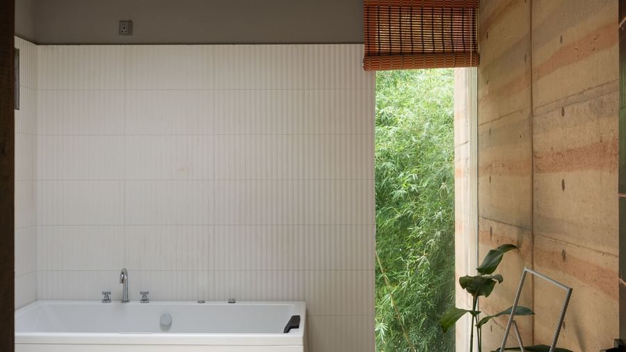 A modern bathroom or utility space with a white countertop, a circular light fixture on the ceiling, and minimalist design | Gaia Studio | RD's Nature Retreat, Bangalore