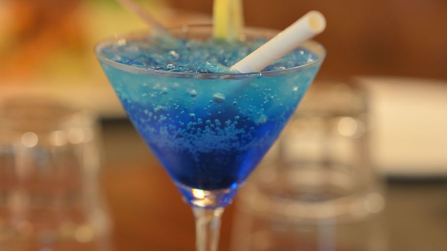 Refreshing blue mocktail garnished with citrus, served in a cocktail glass at Royal Comfort Regency, perfect for a relaxing evening.