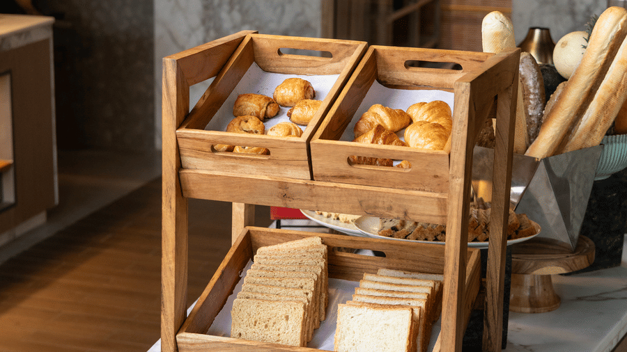 A 2 tier wooden stand filled with fresh bread and pastries at Sands Point Hotel, Pondicherry.