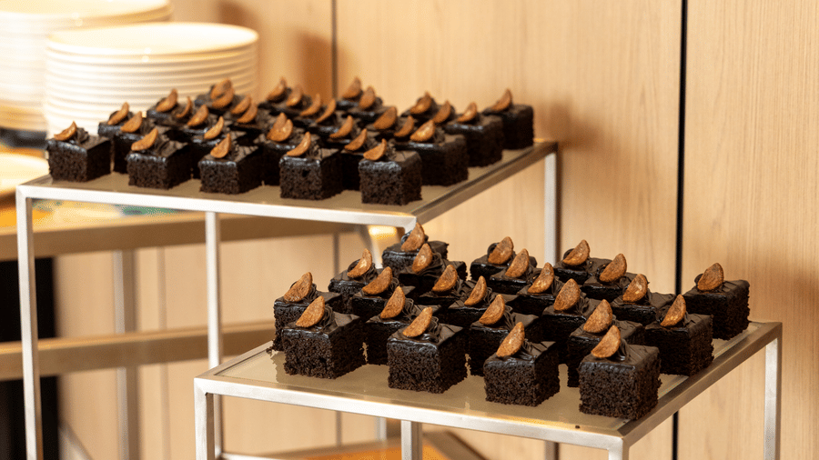 Rows of dark chocolate cupcakes displayed on 2 modern silver tiered stands at Sands Point Hotel, Pondicherry.