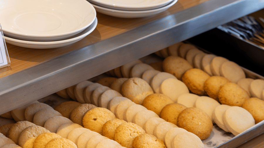 Several white mugs stacked next to 1 tray of freshly baked croissants at Sands Point Hotel, Pondicherry.