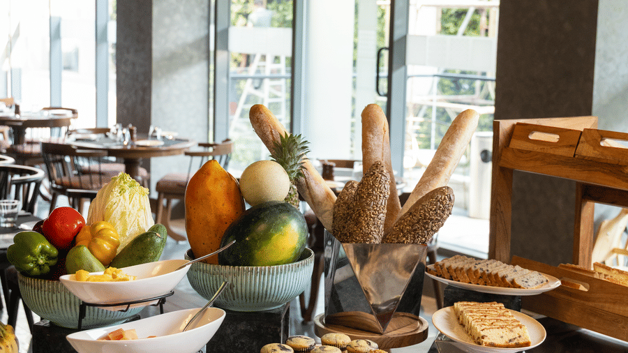 An abundant buffet spread with 1 basket of tropical fruits and assorted artisanal breads at Sands Point Hotel, Pondicherry.