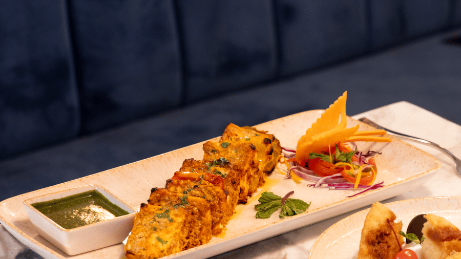 A selection of 3 gourmet dishes including kebabs and salads served on a table at Sands Point Hotel, Pondicherry.