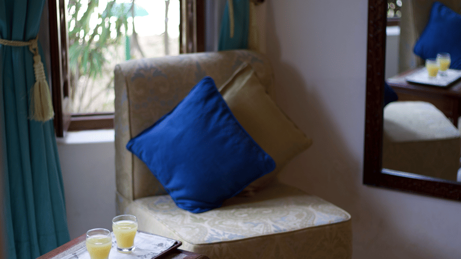 Cosy lounge corner with plush seating, wooden furnishings and garden views at Shahpura Bagh.