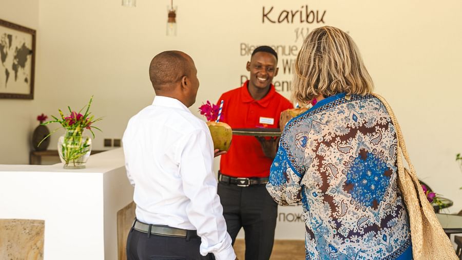 Staff at Shooting Star boutique hotel welcoming a guest with cocount water in the reception