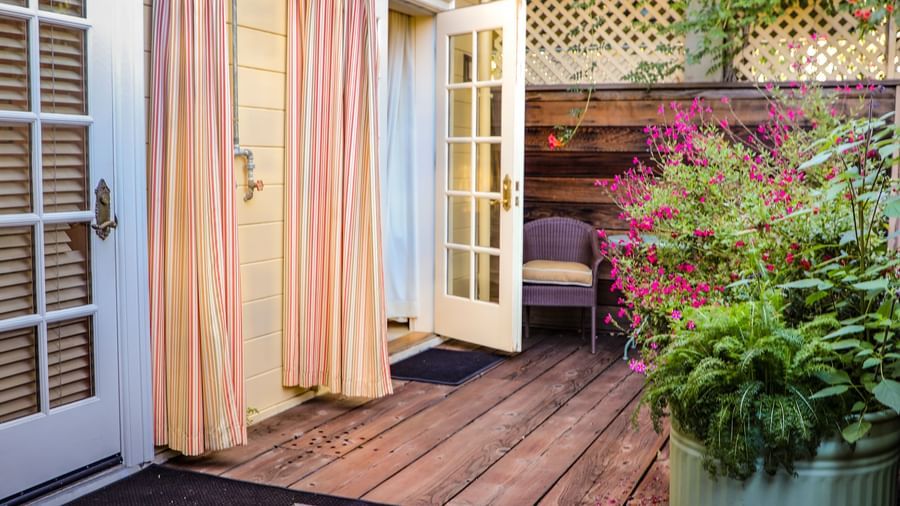 A private patio at the Tallman Hotel contains a wooden deck, an umbrella, and a small water feature.