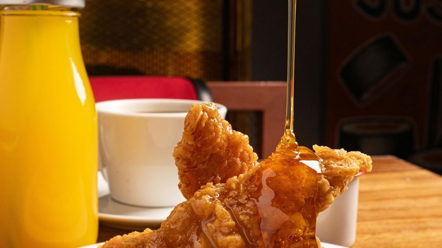 Golden fried chicken tenders on a waffle with a side of orange juice at the Tallman Hotel.