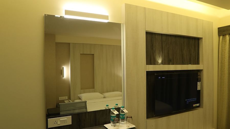 Executive Room showcasing twin beds with white linens, beige walls, and curtains, lit by warm lighting and featuring a unique ceiling design.