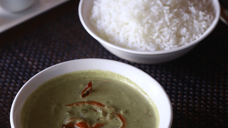 A simple and clean meal presentation featuring a bowl of creamy green soup and a bowl of steamed white rice at The Bull Boutique Hotel.