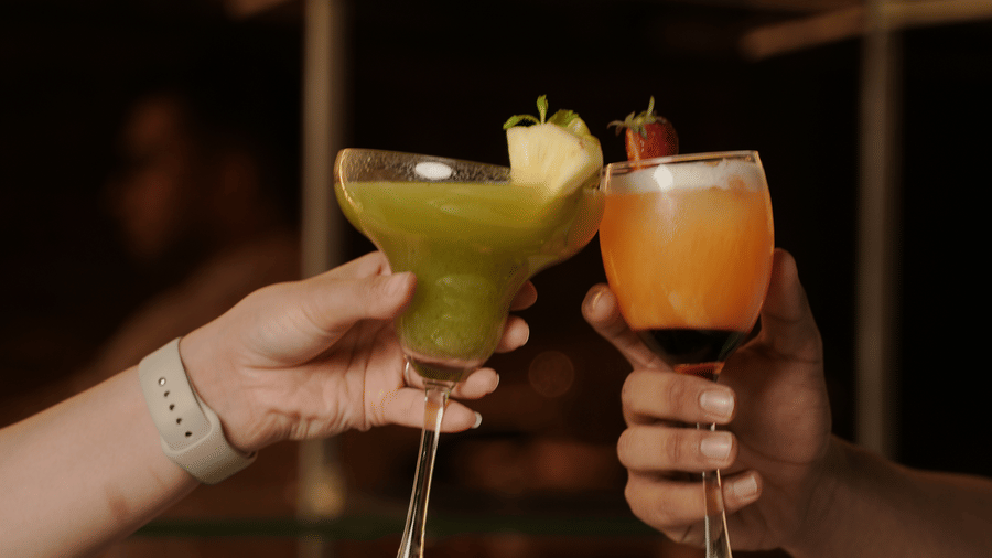 Guests toasting drinks in a lively and vibrant atmosphere at Trino Bar