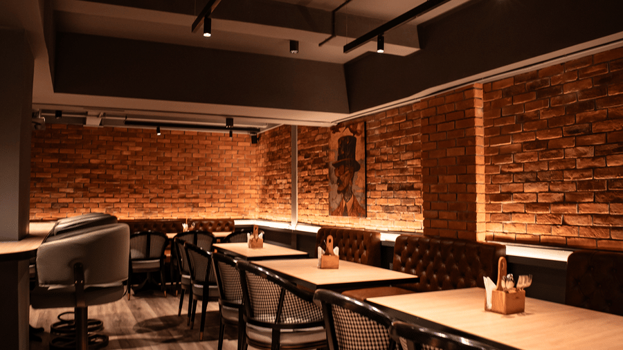 Cosy indoor seating area at Trino Bar with warm lighting, wooden flooring, and stylish chairs