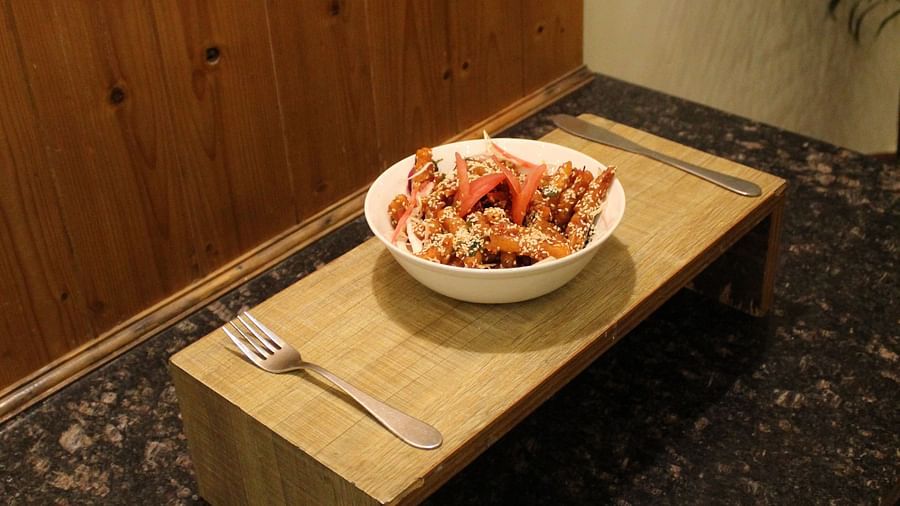 A wooden tray with a food bowl and cutlery placed on a black countertop at Dagshai Manor Kasauli - Inde Hotels.