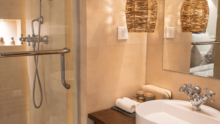 Washroom with a bamboo lamp hanging from the ceiling and toiletries - The Nanee