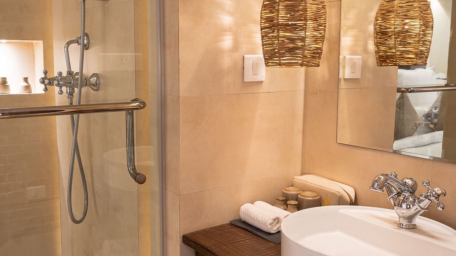 Washroom with a bamboo lamp hanging from the ceiling and toiletries - The Nanee