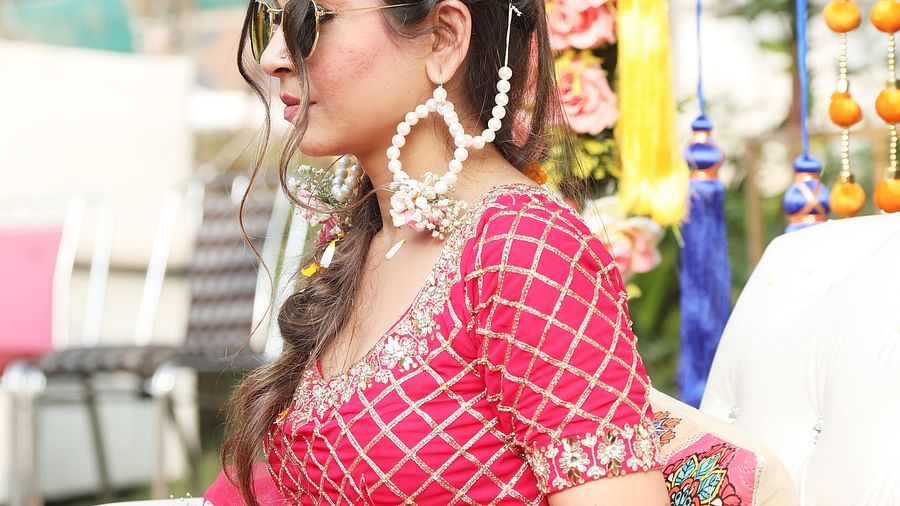 Woman in pink traditional outfit arranging flowers at Tisya Farms, Gurgaon.